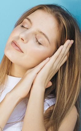 young-woman-with-eye-closed-sleeping-against-blue-backdrop.jpg